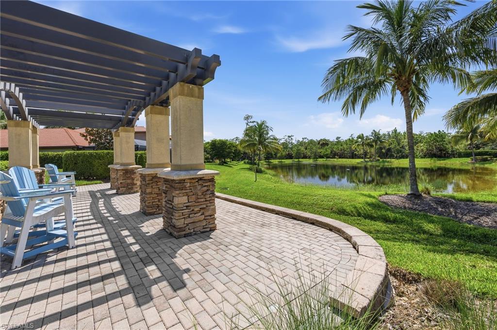 Community park paved patio with pergola, overlooking a tranquil pond
