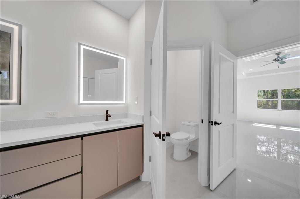 Master bathroom with double vanity featuring quartz countertops, undermount sinks, and illuminated mirrors
