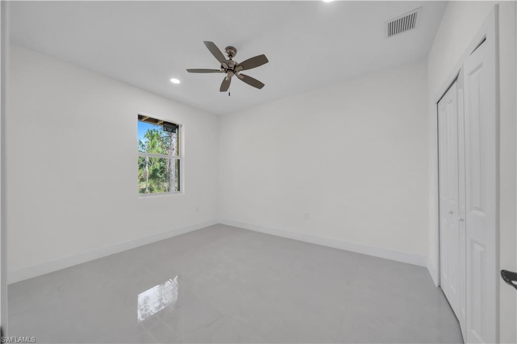 Room featuring white walls, gray tile flooring, and a single window