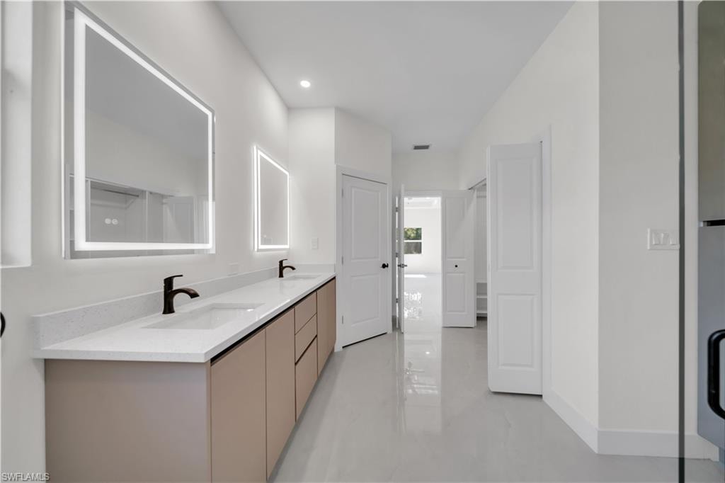 Master bathroom with dual vanity and rectangular undermount sinks, light-toned countertop, and matte black faucets