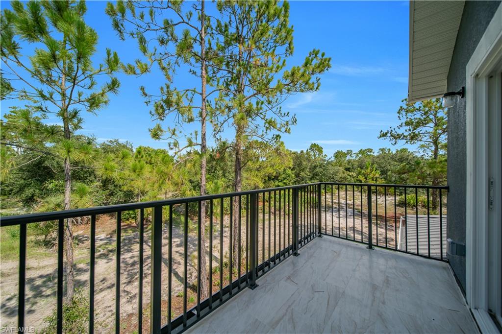 Outdoor balcony featuring tile flooring and black metal railings