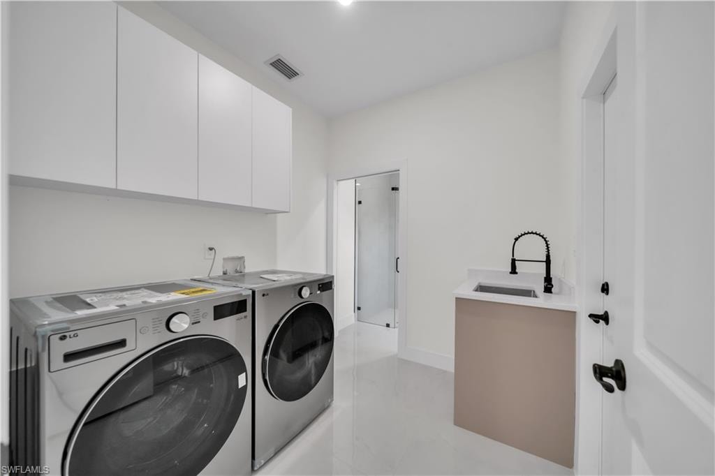 Utility room with white shaker-style cabinetry, a built-in sink with a matte black faucet, and light-toned tile flooring