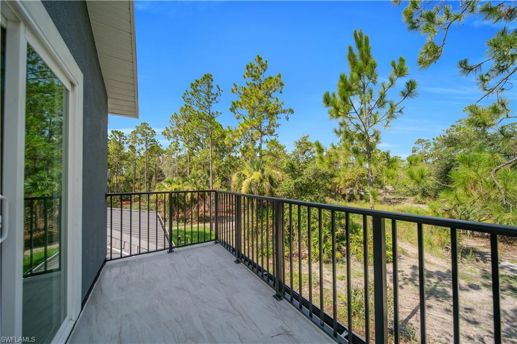 Balcony featuring a sliding glass door, a metal railing, and wood-finish flooring