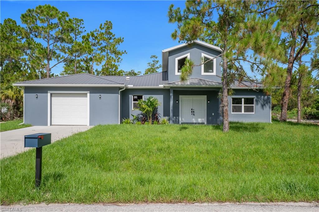 Contemporary-style exterior featuring a gray stucco finish and a coordinating metal roof