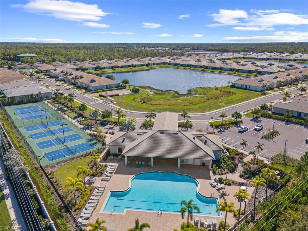 Aerial perspective of suburban area with a pool and a nearby body of water
