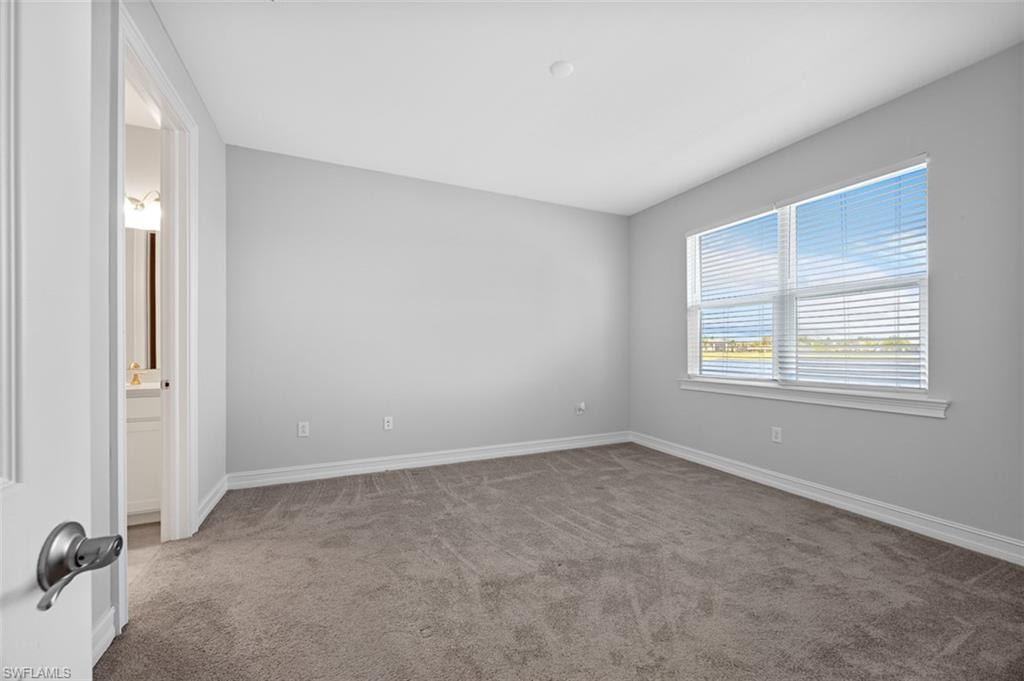 Unfurnished room featuring light colored carpet and baseboards
