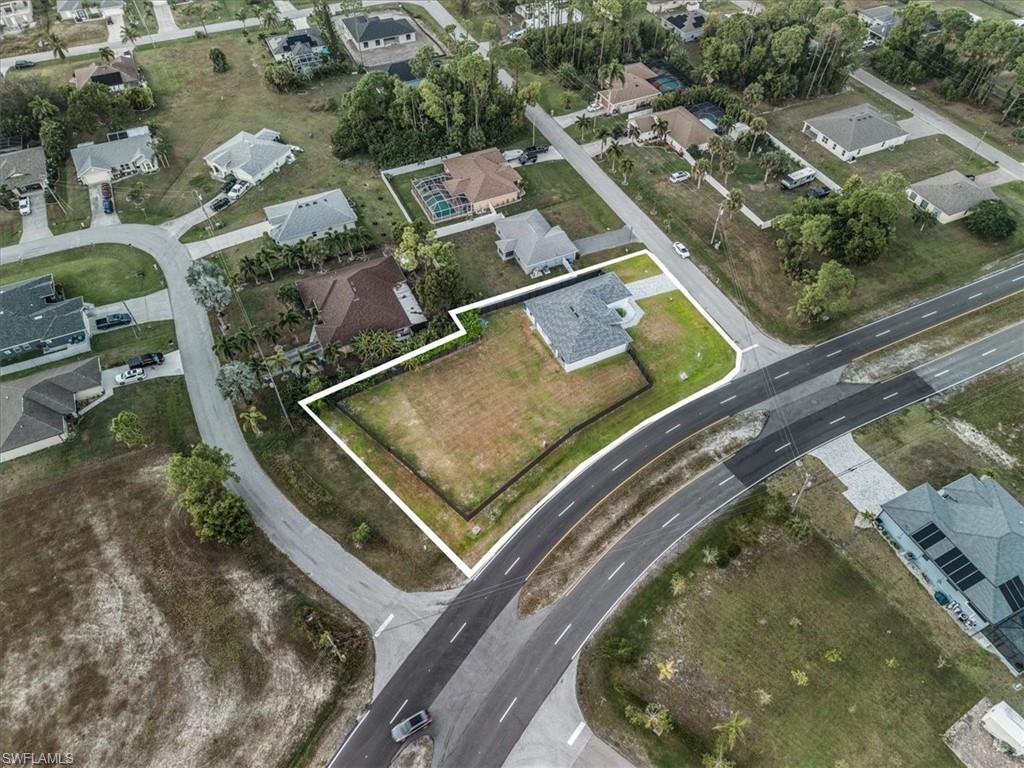 Expansive corner lot featuring a partial privacy fence and direct road access