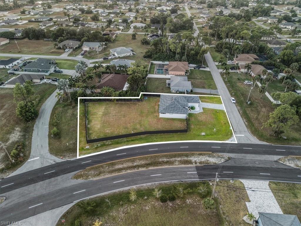 Aerial property overview featuring a single-story residence with a gray shingle roof