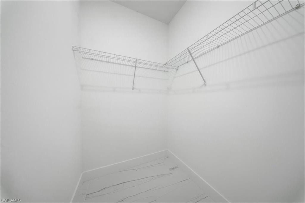 Corner closet with wire shelving and marble-look flooring