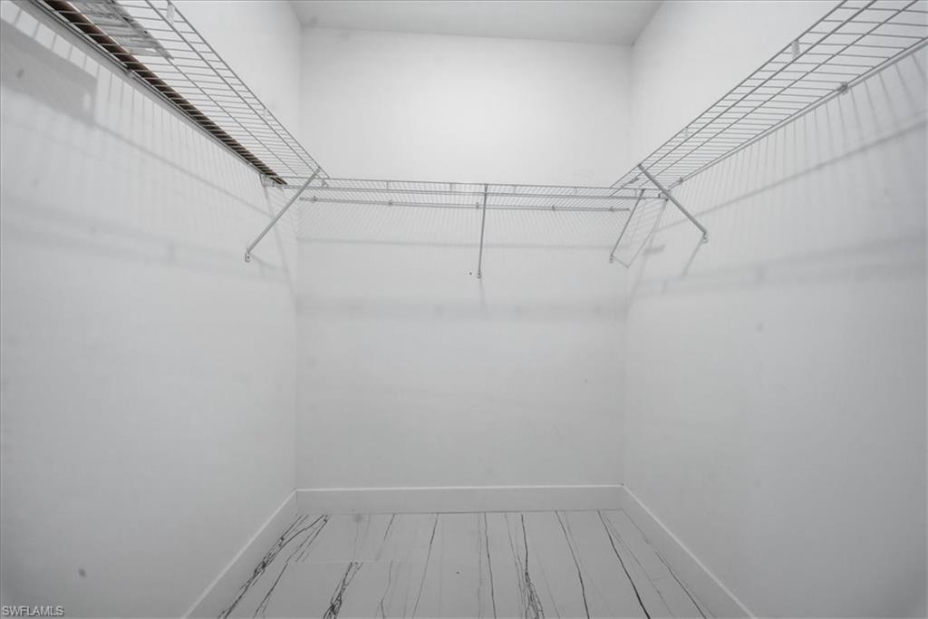 Walk-in closet with wire shelving system and white-finish flooring