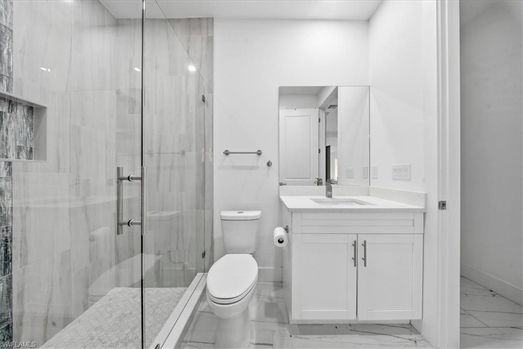 Contemporary bathroom featuring a frameless glass shower enclosure with a built-in niche