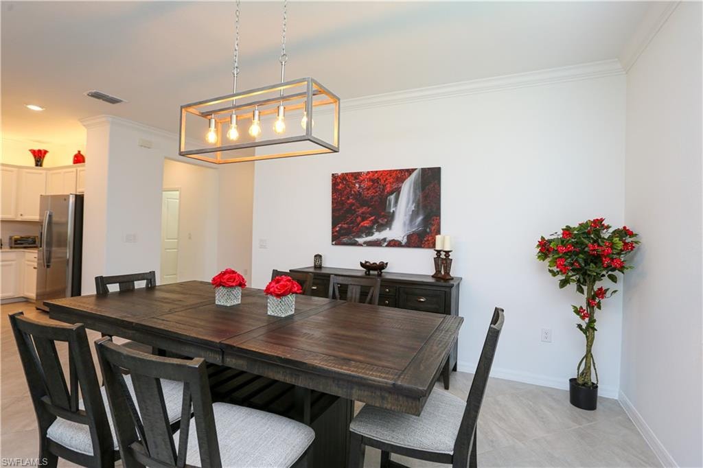 Tiled dining room featuring ornamental molding