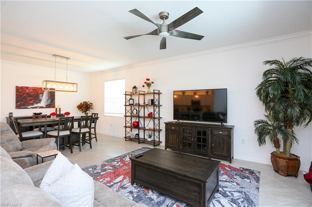 Tiled living room featuring ornamental molding and ceiling fan