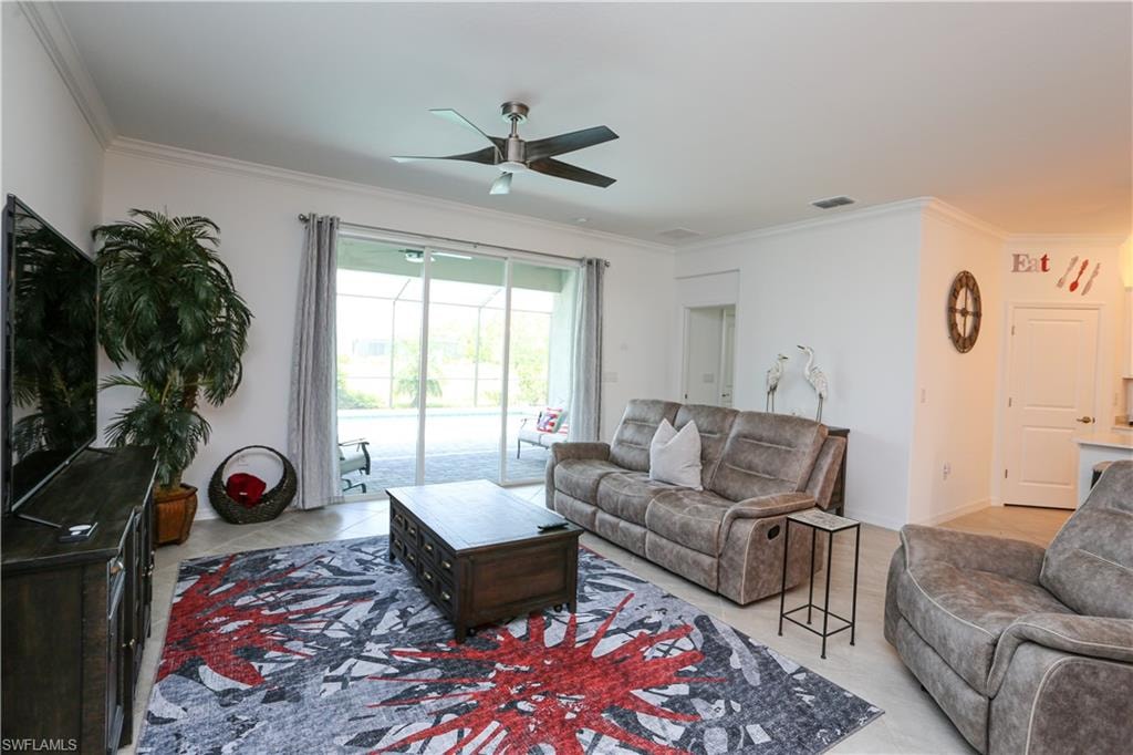 Living room featuring ceiling fan and crown molding