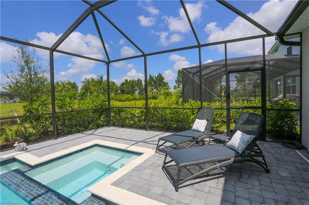 View of pool featuring a lanai, a patio, and an in ground hot tub