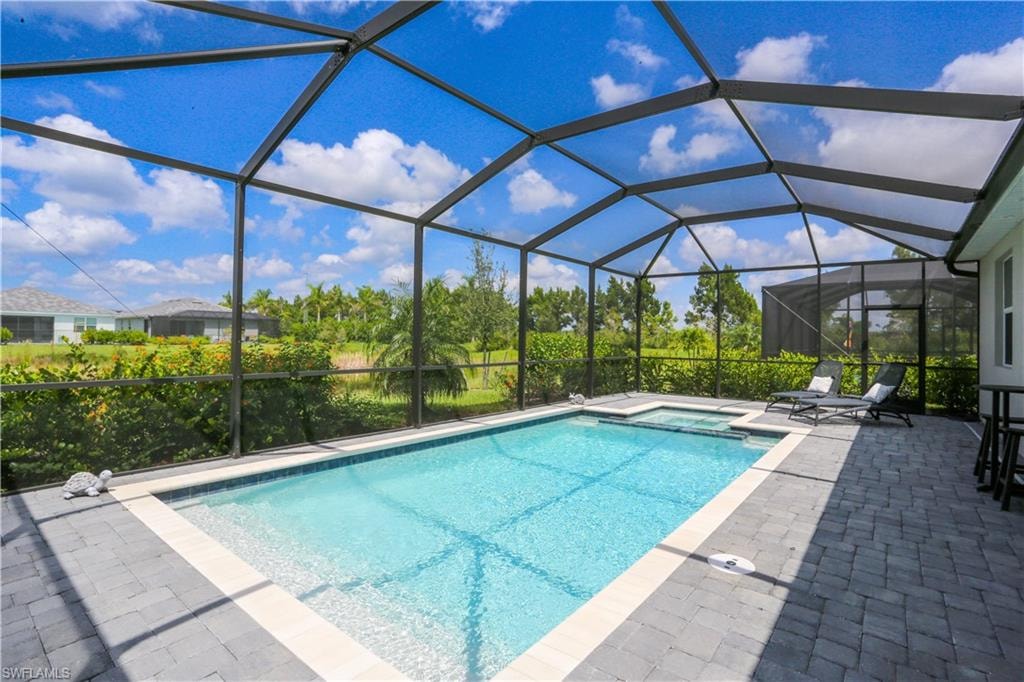 View of swimming pool featuring a patio and a lanai