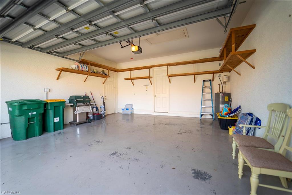 Garage featuring a garage door opener and water heater