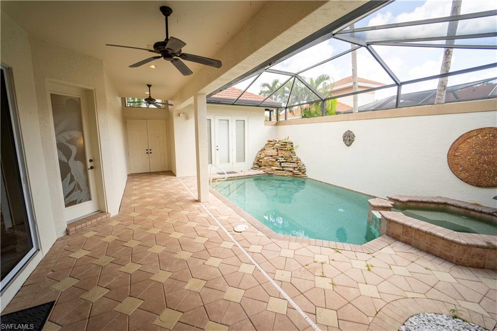 View of swimming pool with an in ground hot tub, a lanai, ceiling fan, and a patio area