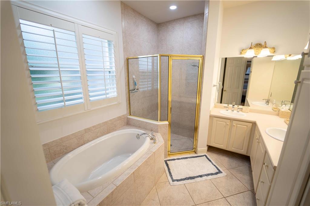 Bathroom featuring tile patterned flooring, independent shower and bath, and vanity