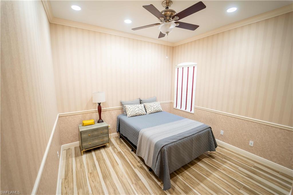 Bedroom featuring ceiling fan, hardwood / wood-style floors, and crown molding