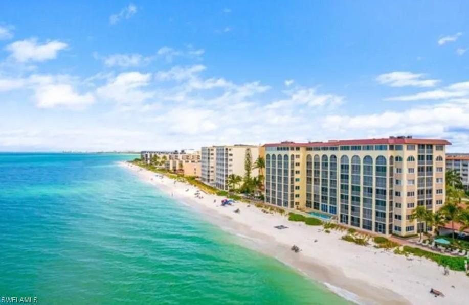 Birds eye view of property with a beach view and a water view