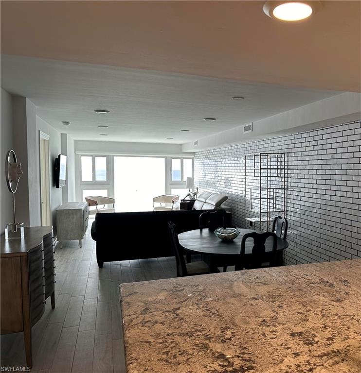 Dining room featuring dark hardwood / wood-style flooring and brick wall