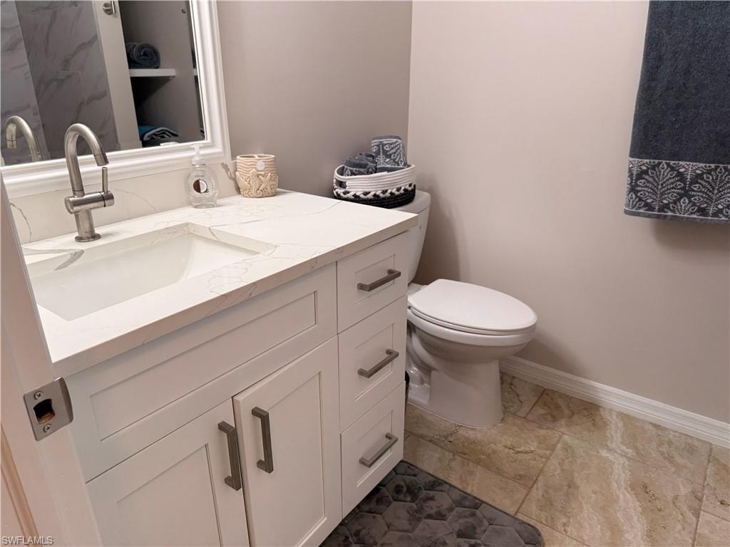 Bathroom featuring a white vanity with slab-front drawers, a countertop with an integrated rectangular sink, a single-handle faucet, and tile flooring