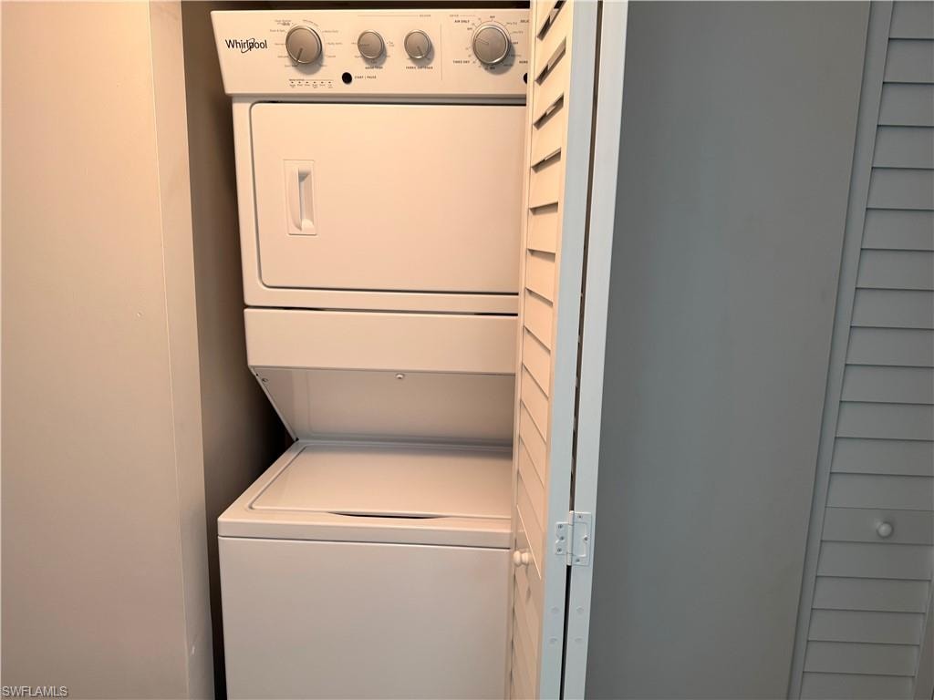 White stackable Whirlpool washer and dryer unit within a dedicated utility closet