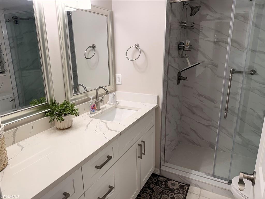 Bathroom featuring a white vanity with an integrated sink, quartz countertop, and brushed nickel hardware