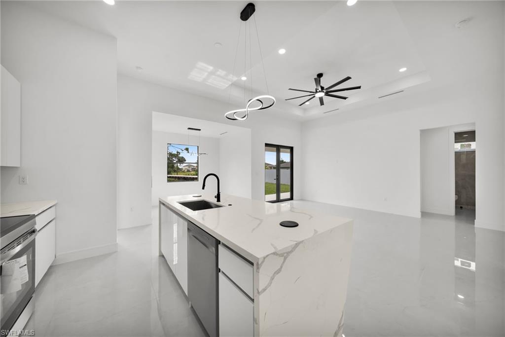 Contemporary kitchen island with a waterfall countertop, integrated sink, and matte black faucet