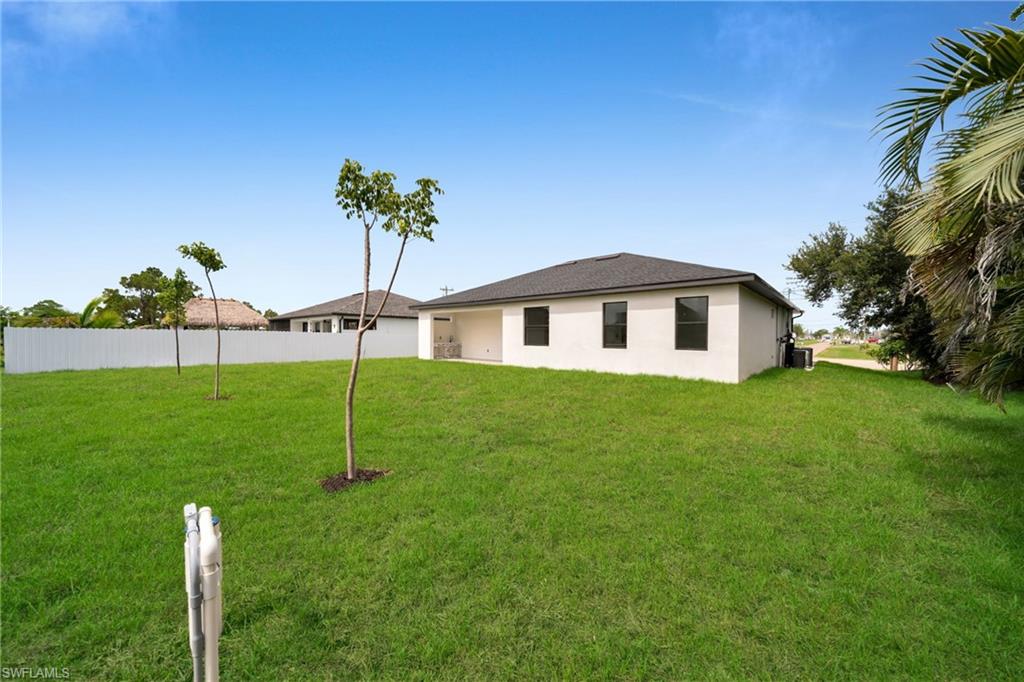 Expansive green lawn with young trees