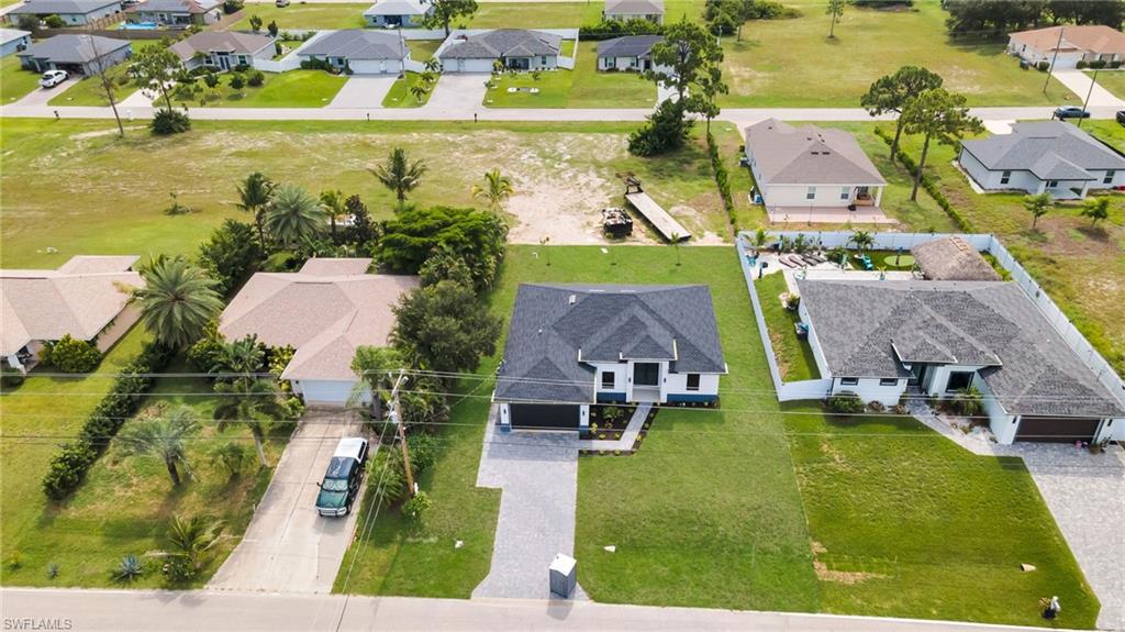 Modern single-story residence featuring a dark shingle roof and a light-colored exterior