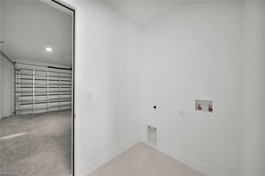 Dedicated laundry area with hookups, white baseboards, and neutral wall tones