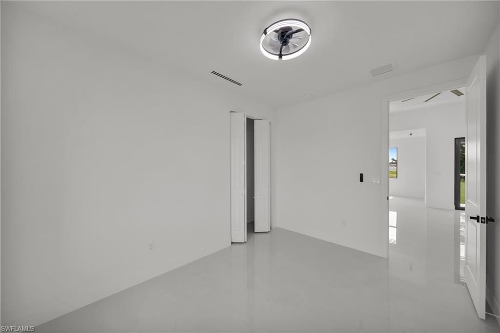 Crisp white walls define this interior space, featuring a modern ceiling fan with integrated lighting