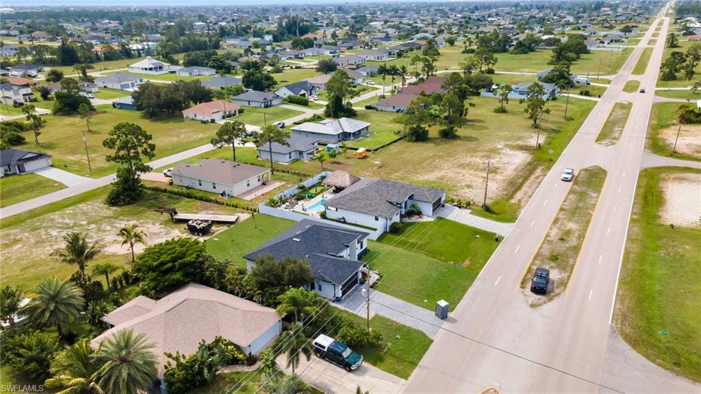 Aerial perspective showcasing a residential area with single-story homes, established landscaping, and paved streets
