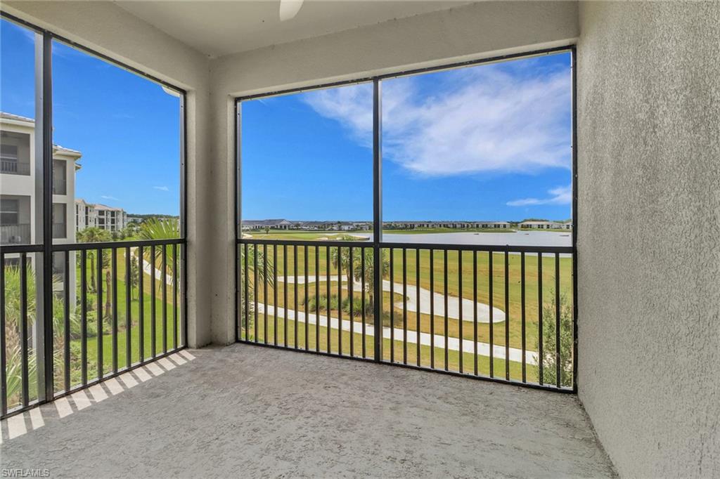 Screened balcony with textured flooring, featuring a metal railing system