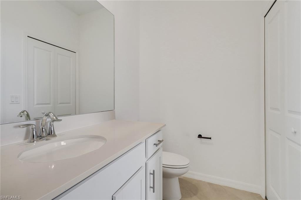 Bathroom vanity with an integrated sink, polished chrome faucet, and white countertop