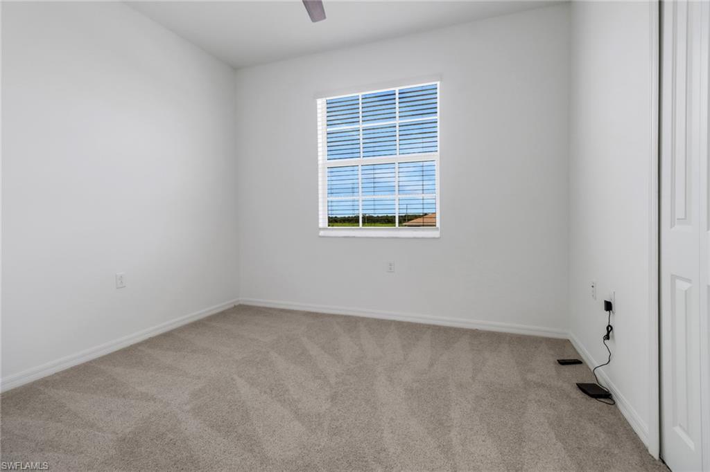 Room featuring neutral tone carpeting and white baseboards