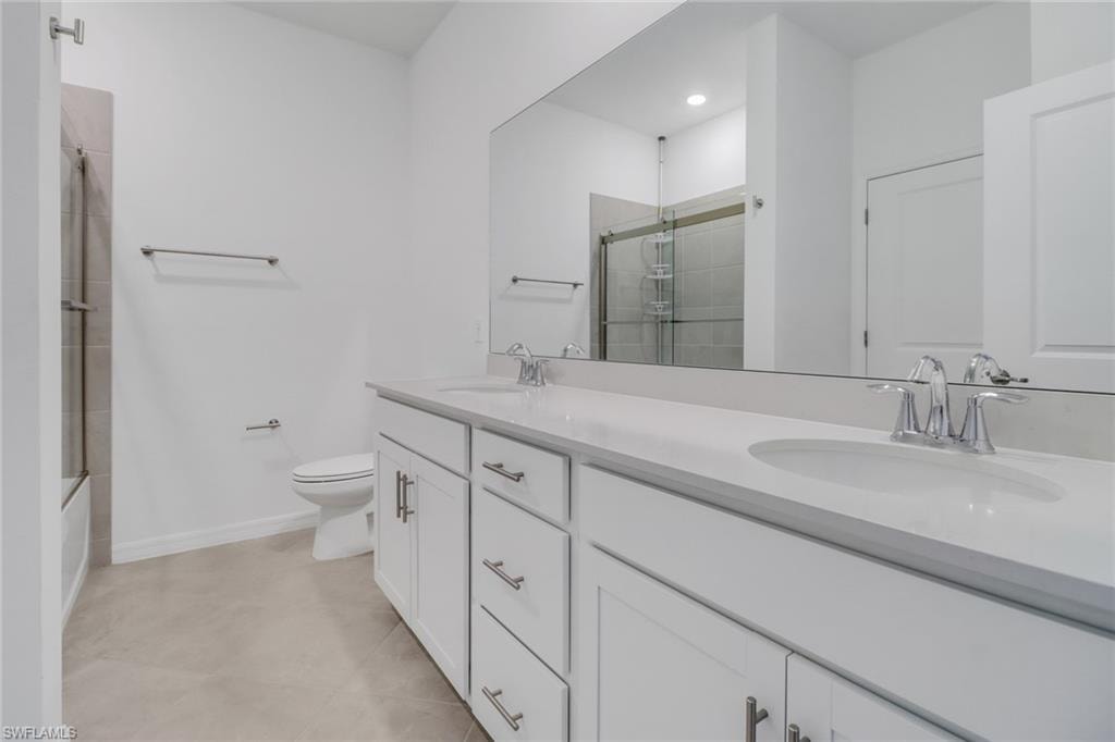 Double vanity with white cabinetry and chrome hardware, featuring undermount sinks and light-toned countertops