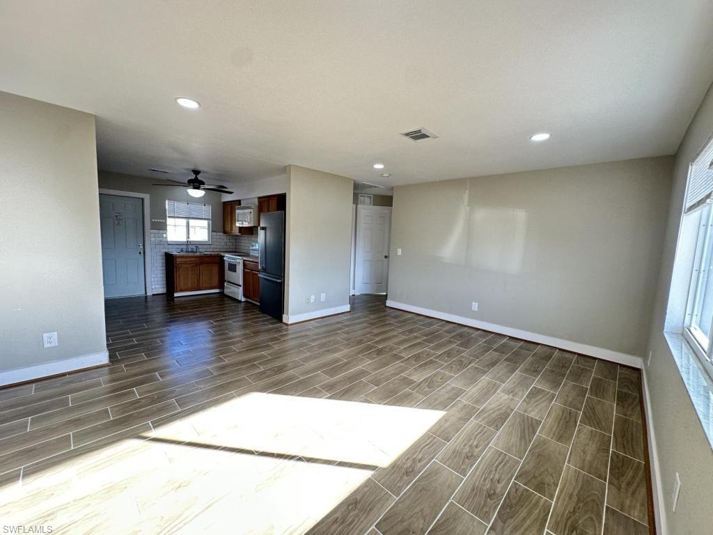 Unfurnished living room with wood finish floors, ceiling fan, and recessed lighting