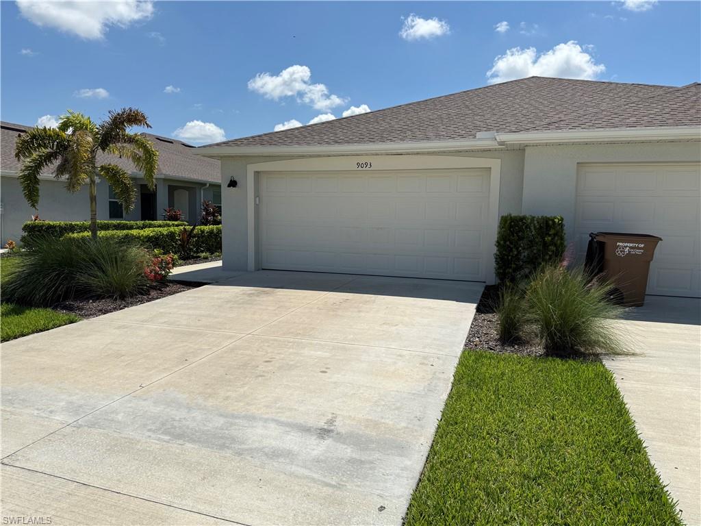 Exterior featuring a two-car garage, concrete driveway, and a shingle roof
