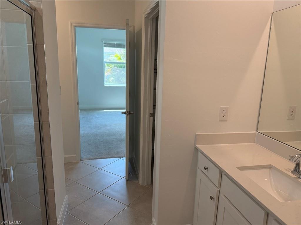 Bathroom vanity with white cabinetry, light-toned countertop, and undermount sink