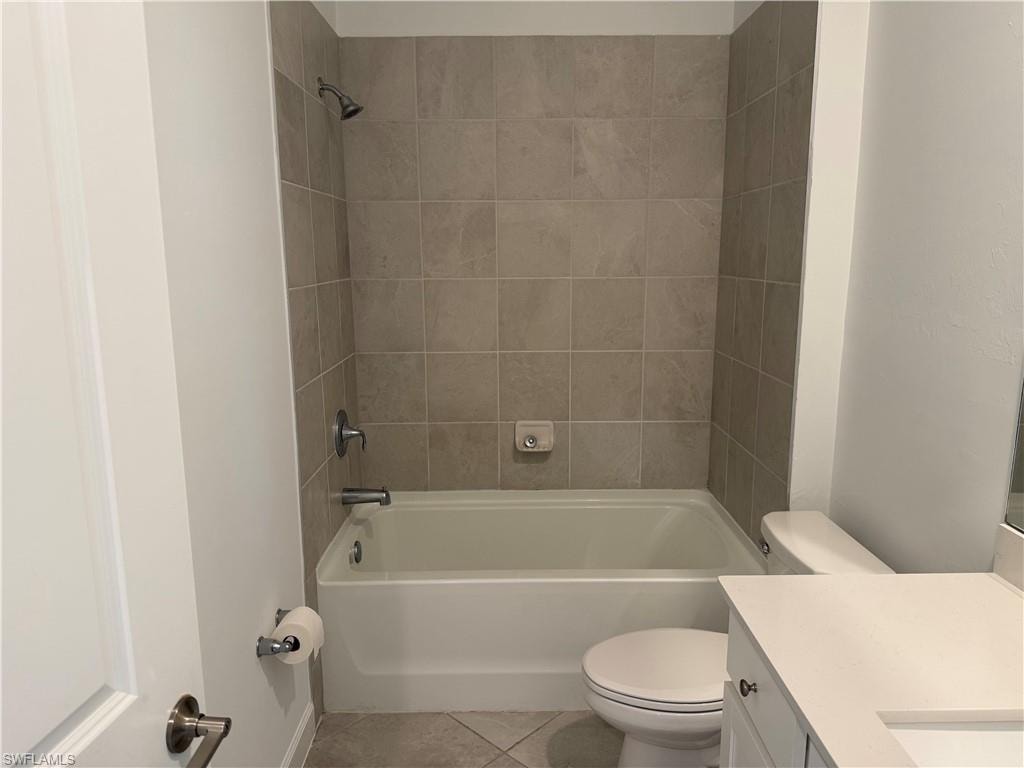 Bathroom featuring a white bathtub, ceramic tile surround, and brushed nickel fixtures