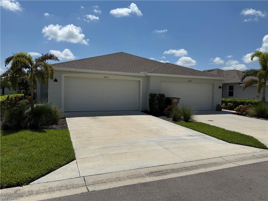 Contemporary duplex exterior with a neutral stucco finish and a brown shingle roof