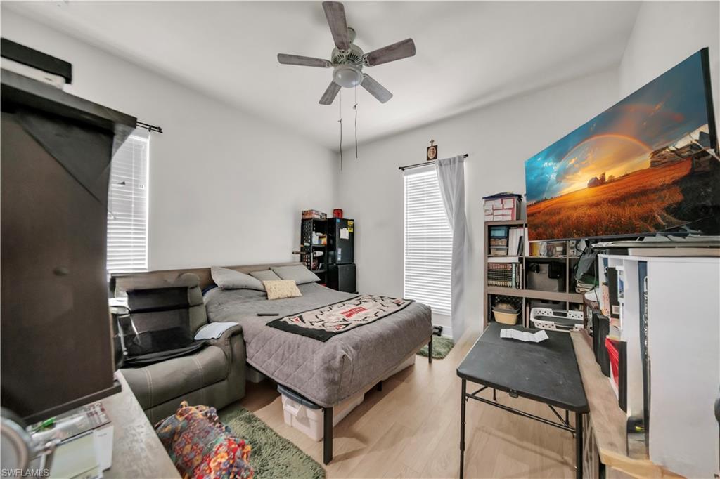 (3rd Bedroom)Well-lit interior space featuring wood-finish flooring, a ceiling fan with integrated lighting, and multiple windows with blinds