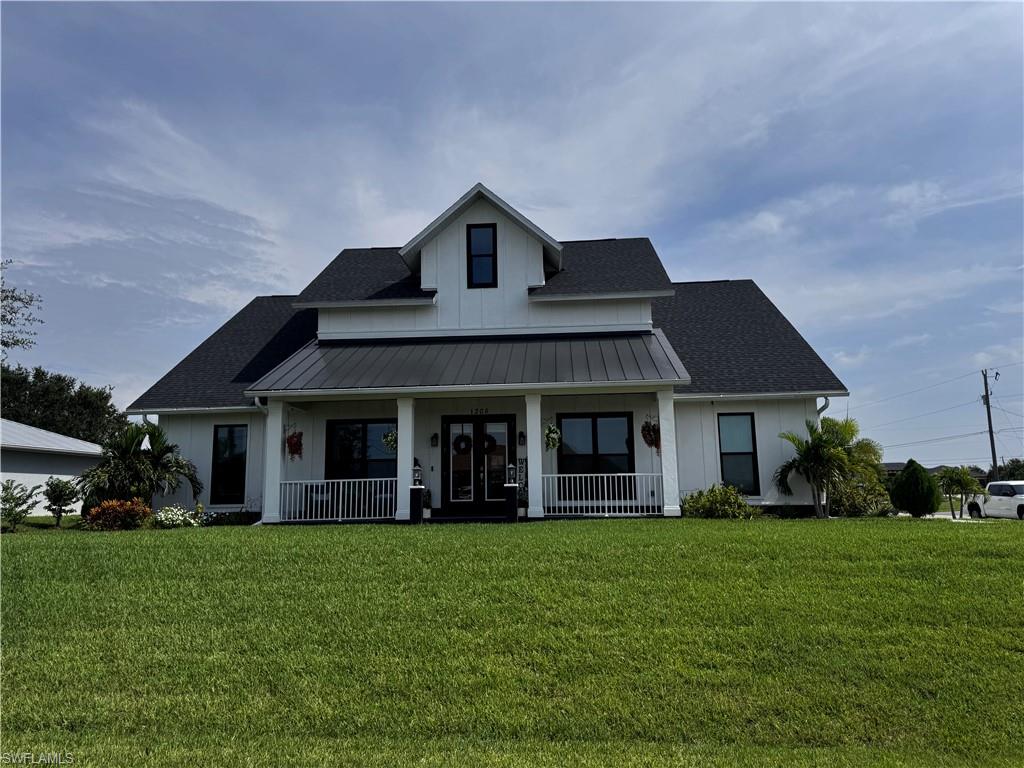 Modern farmhouse exterior featuring white board and batten siding, a dark shingled roof, and a prominent front porch with white railings