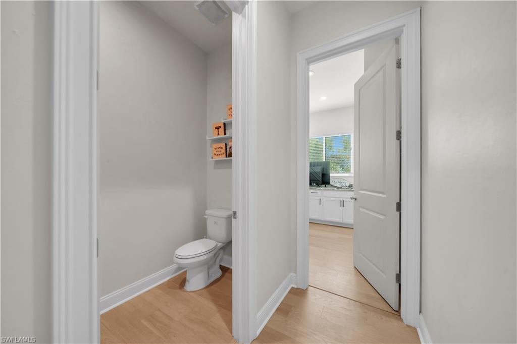 Half-Bathroom with wood-finish flooring and light gray walls