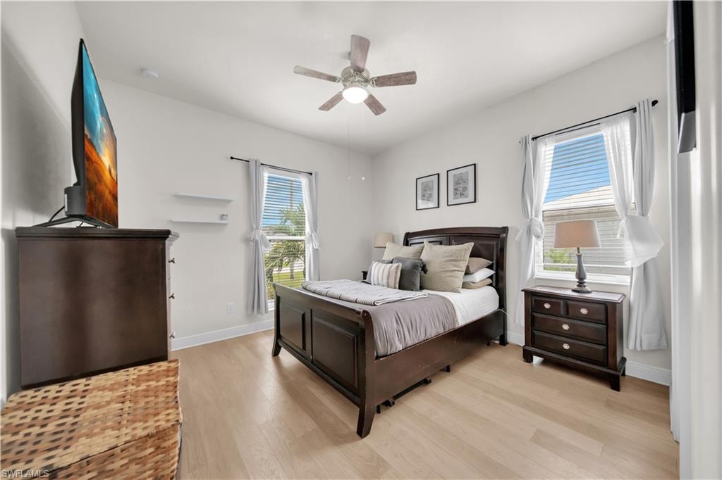 (Second Bedroom)featuring light wood-finish flooring, white walls, and a ceiling fan with integrated lighting