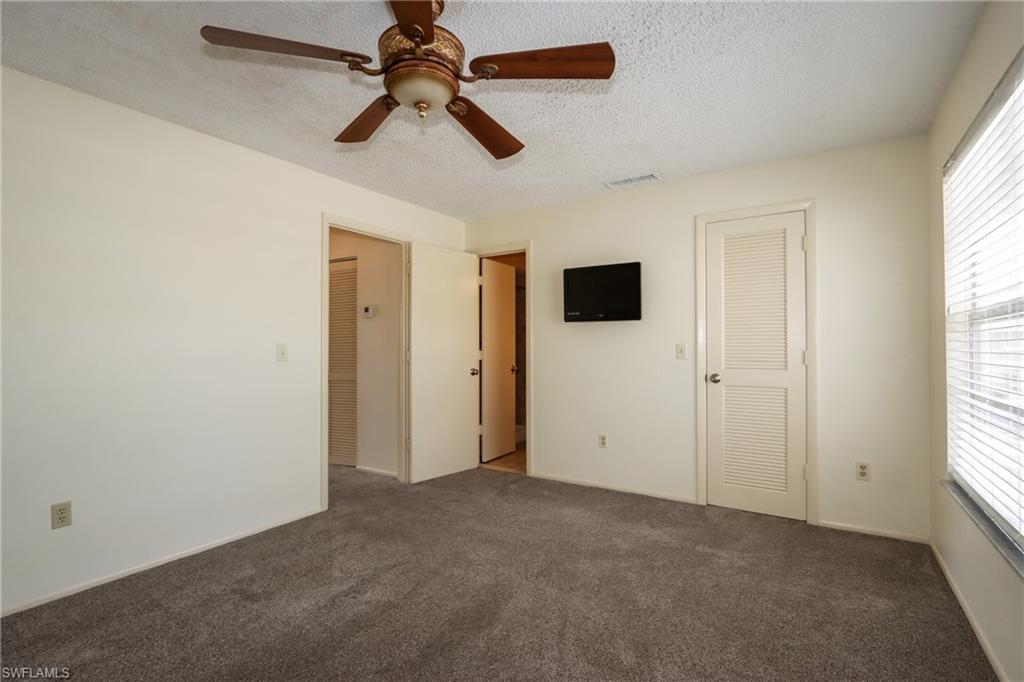 Unfurnished bedroom with a textured ceiling, carpet flooring, a ceiling fan, and a closet