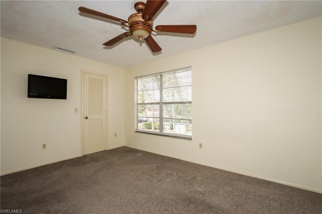 Spare room with dark colored carpet and a ceiling fan